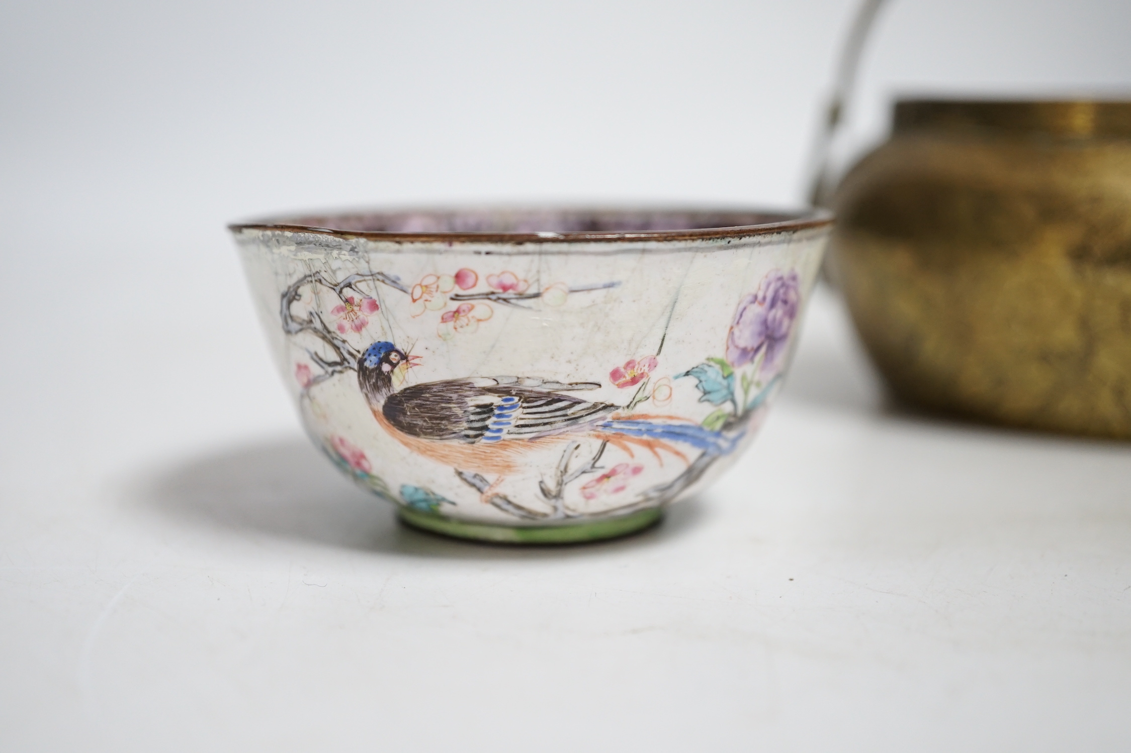 A Chinese bronze hand warmer, 11.3cm and an 18th century Chinese Canton enamel cup, cup 7cm diameter